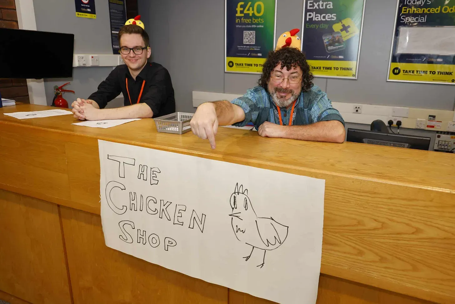 Volunteers manning the pretend chicken shop, standing behind a counter