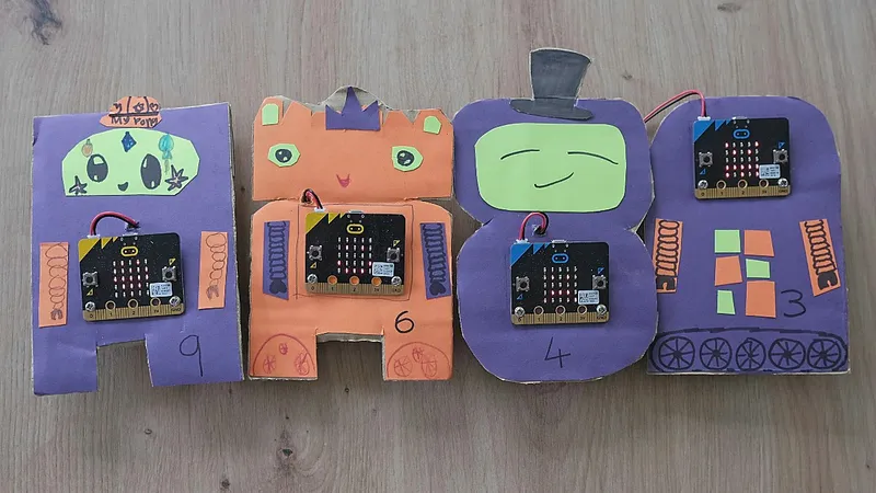 Four cardboard robots with micro:bits attached.